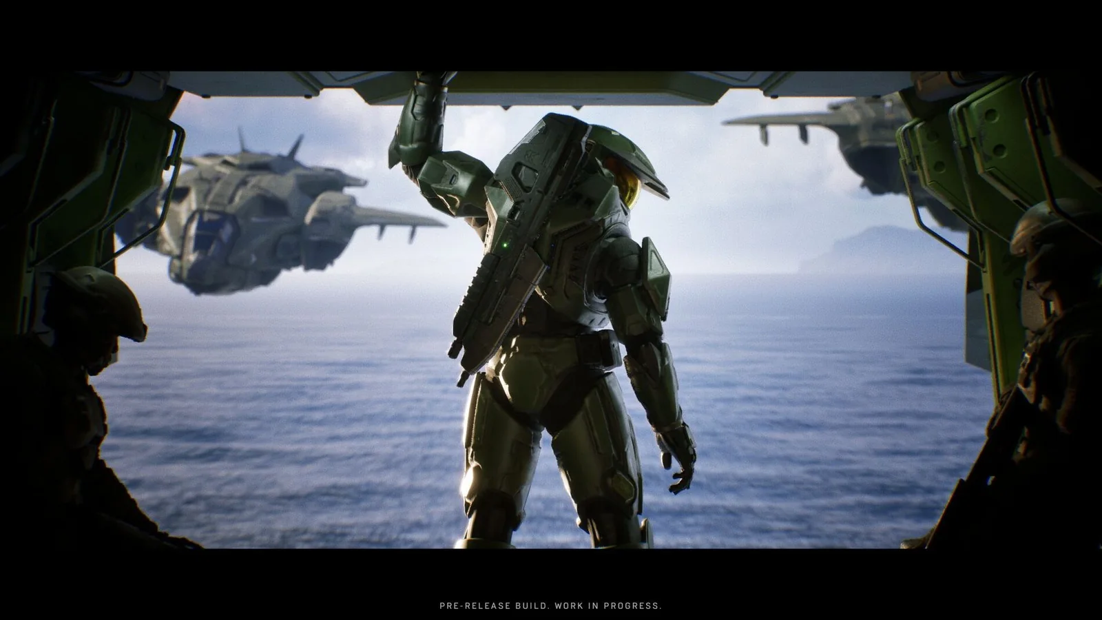 Master Chief standing in the open rear bay of a UNSC aircraft above the ocean