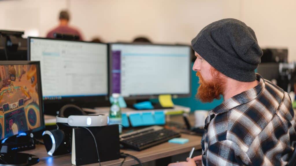 FuturLab Cancels Project as Seven Employees Leave Studio Official FuturLab office photo showing a developer working at a multi-monitor game-development workstation