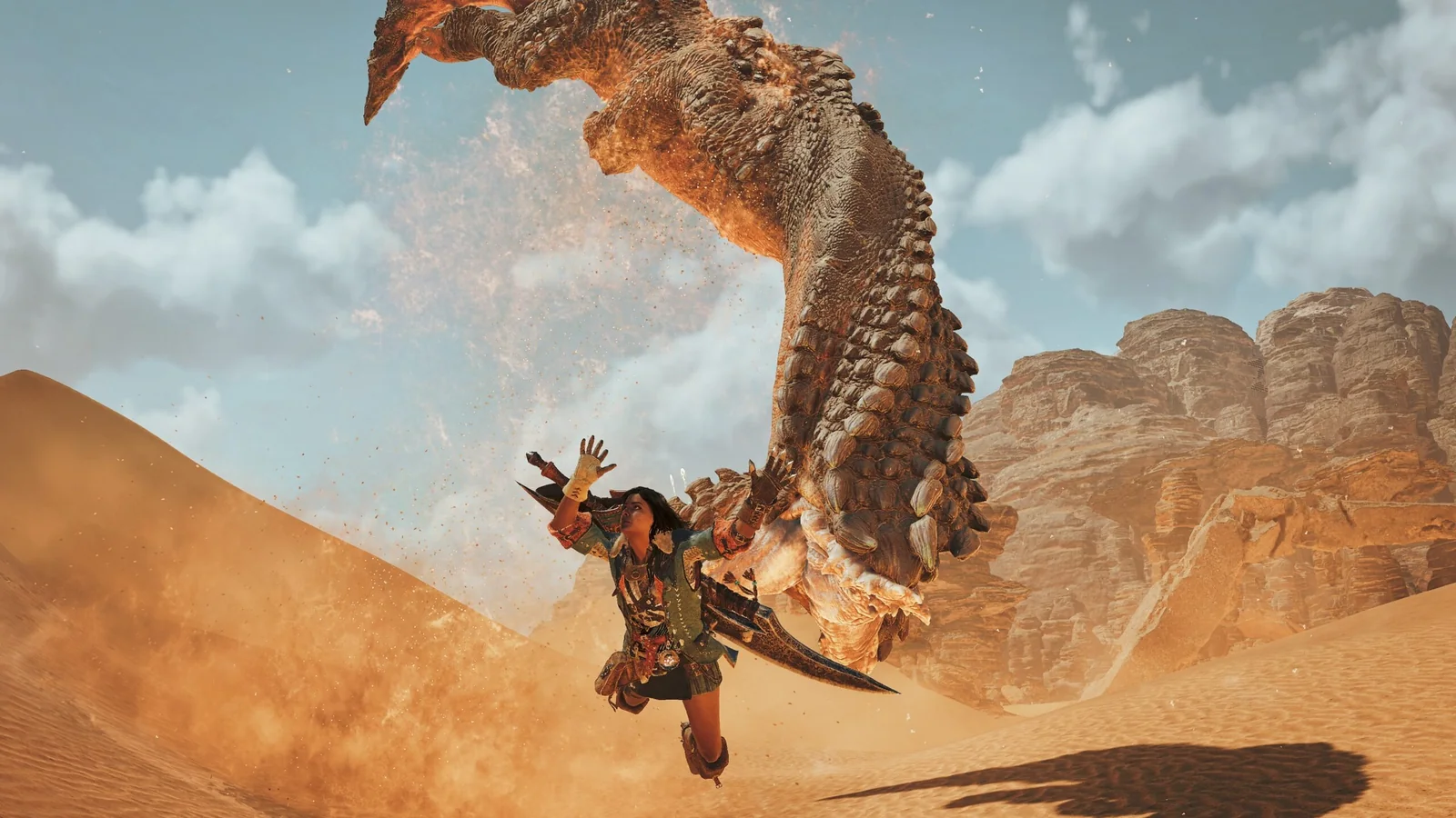 Official Monster Hunter Wilds screenshot showing a hunter being attacked by a large monster in the desert