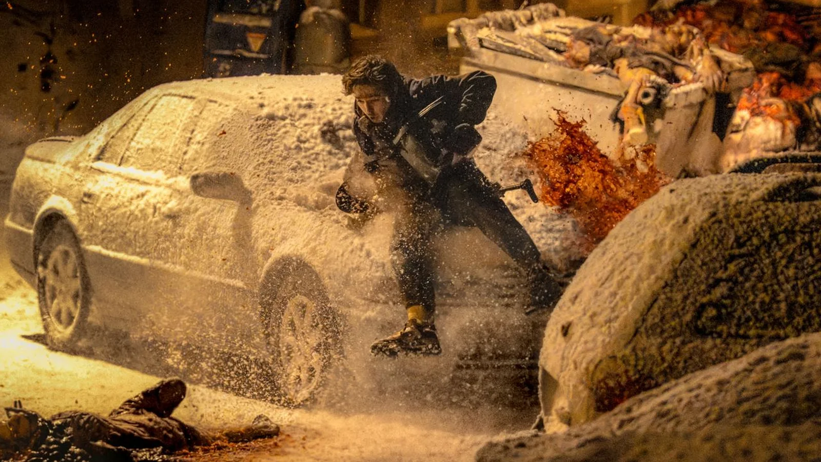 Austin Abrams as Bryan fleeing through a snow-covered street as an explosion erupts behind him