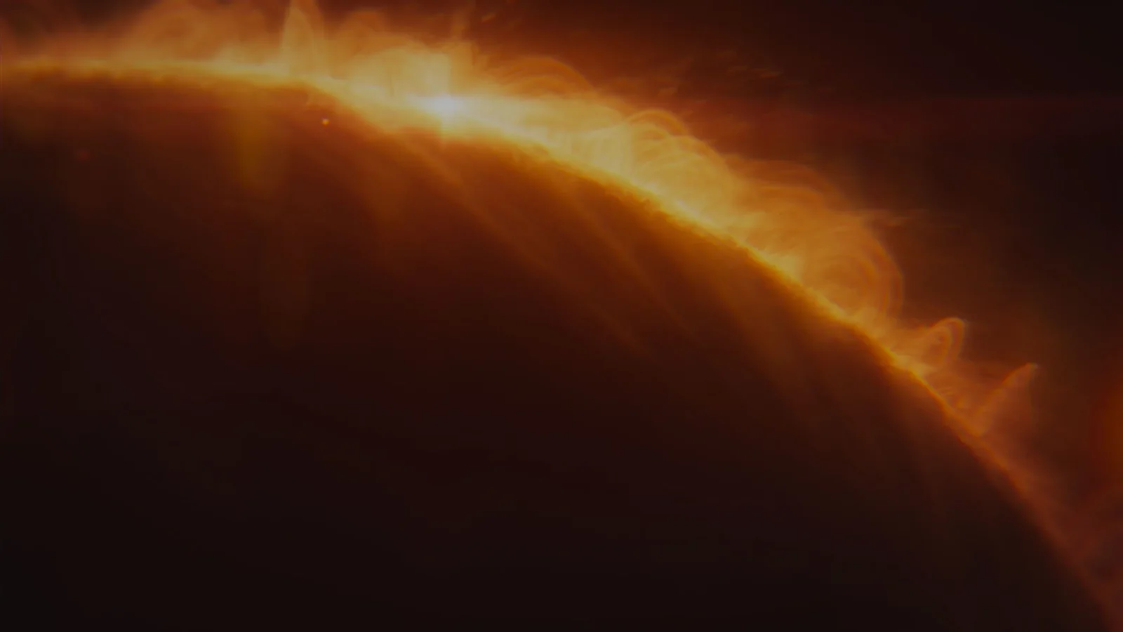 Official Saros cinematic image showing Arjun confronting a towering multi-armed enemy under an orange eclipse