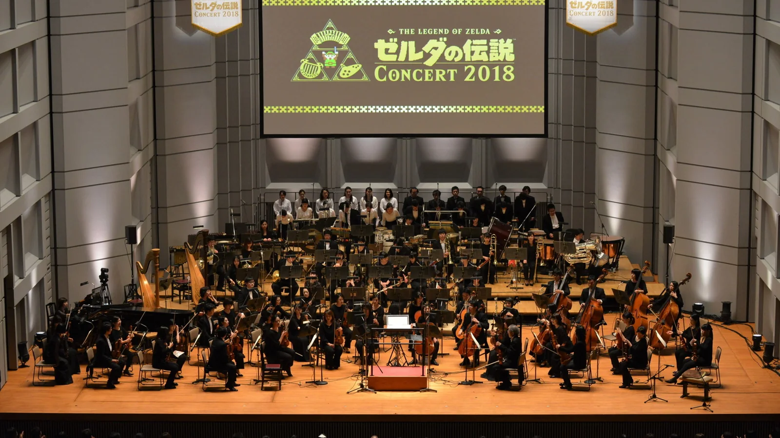 The Legend of Zelda Concert 2018 orchestra performing beneath Breath of the Wild footage on a large screen