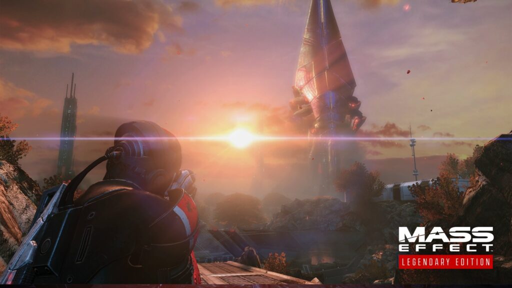Mass Effect Legendary Edition screenshot showing an alien environment with a towering futuristic structure illuminated