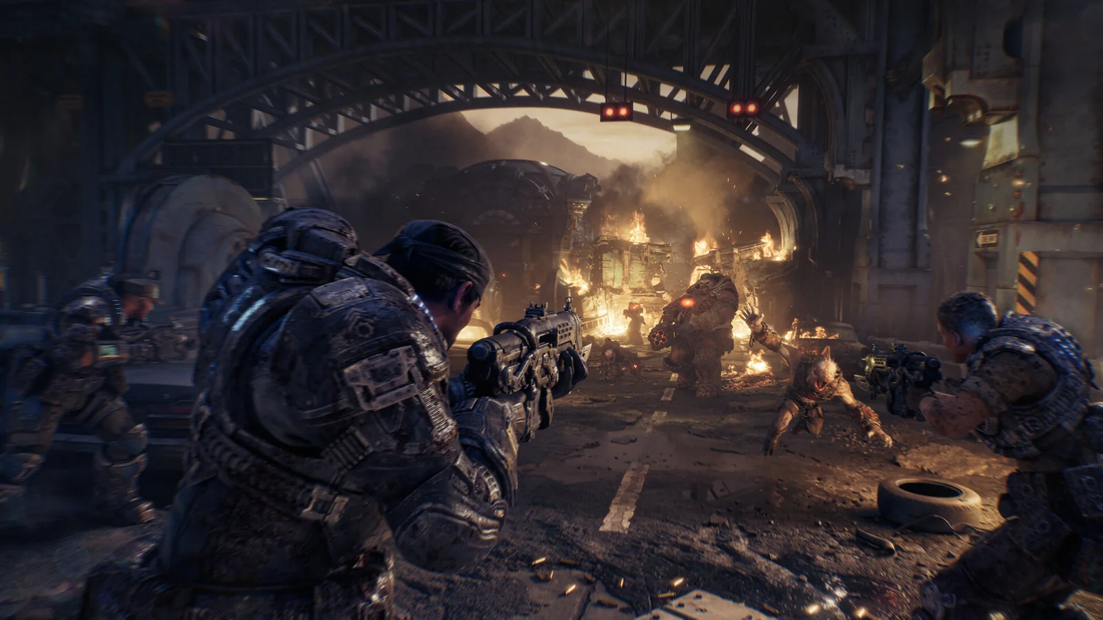 Gears of War: E-Day gameplay screenshot showing COG soldiers fighting Locust enemies inside a burning industrial passage
