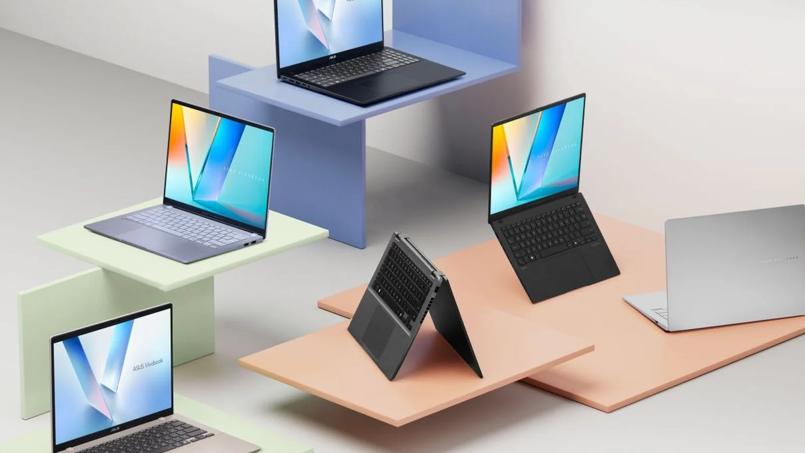 ASUS 2026 laptop lineup featuring multiple Zenbook-style notebooks arranged on pastel-colored platforms