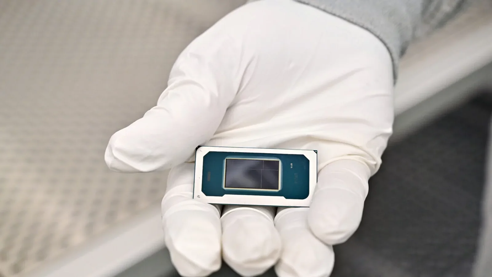 Intel manufacturing technician holding a Core Ultra Series 3 processor inside Fab 52