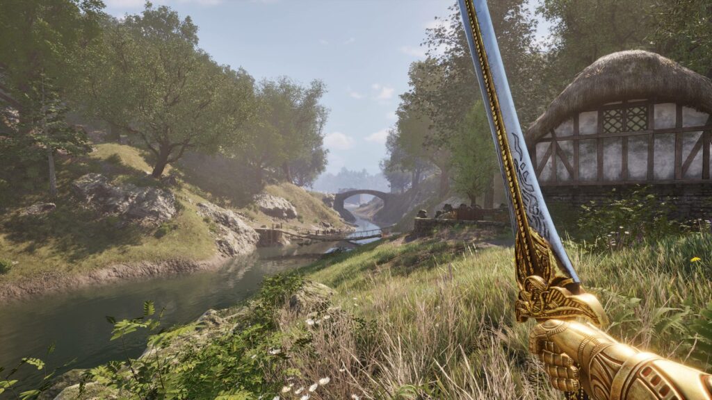 Golden sword raised beside a picturesque river, stone bridge, and countryside buildings