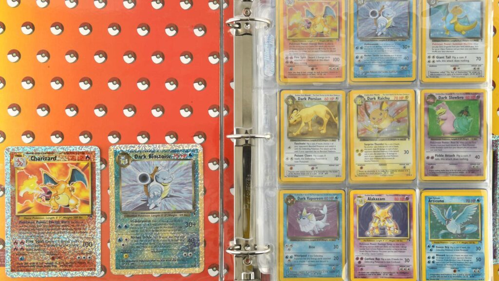 Pokémon Card Collection Sells for £1.56 Million at UK Auction Open Pokémon card binder displaying rare Charizard and Dark Blastoise holographic cards alongside additional vintage