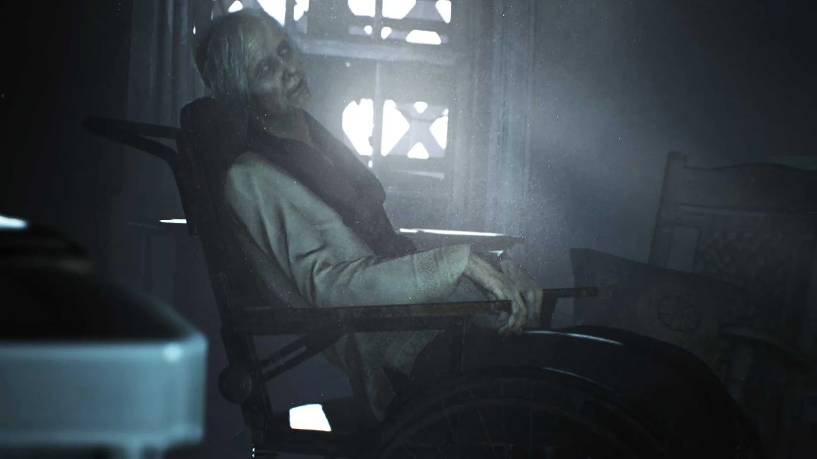 Official Resident Evil 7 screenshot featuring an elderly woman sitting in a wheelchair inside a dimly illuminated room