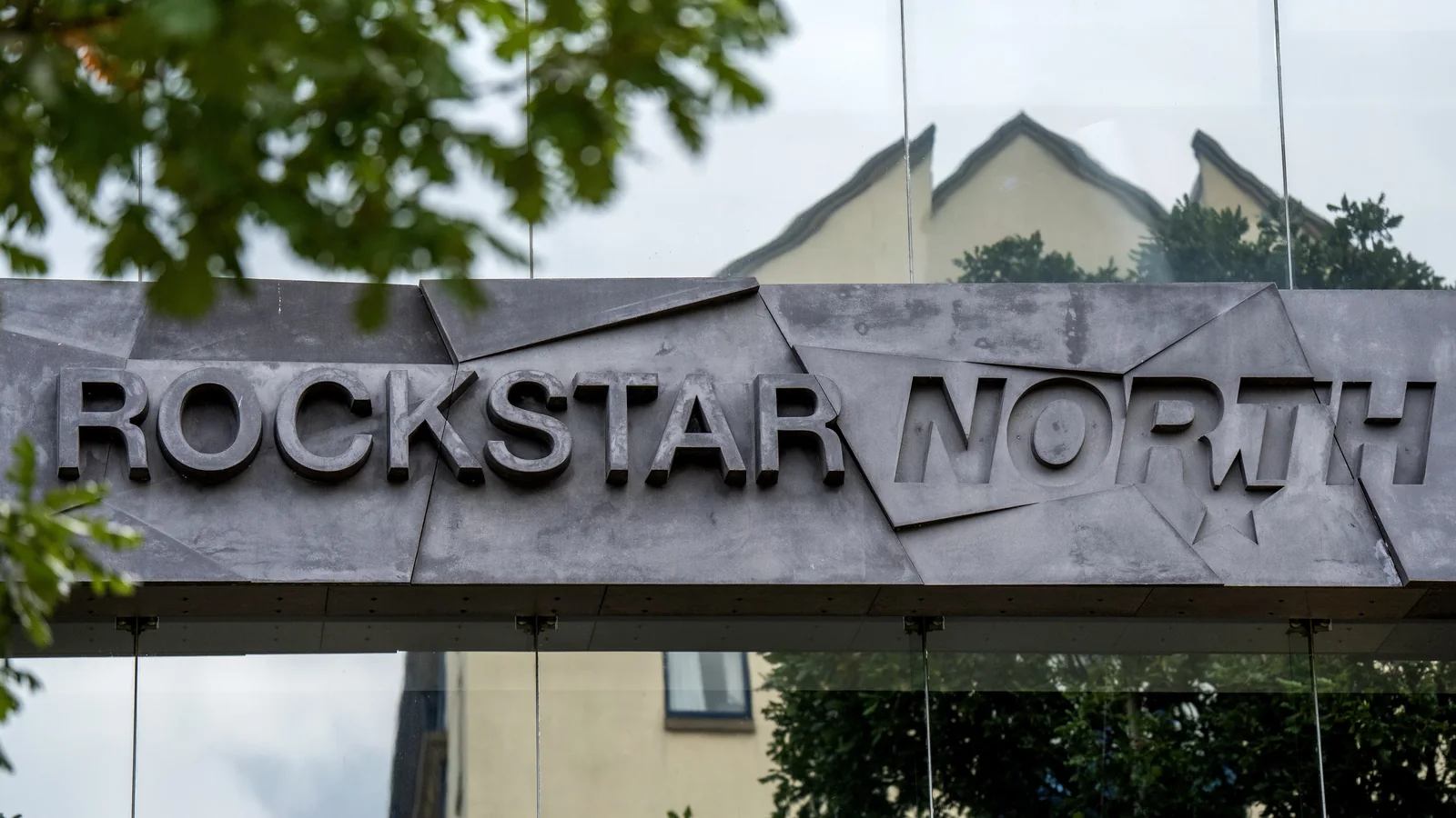 Close-up photograph of the Rockstar North headquarters entrance with the company name displayed prominently