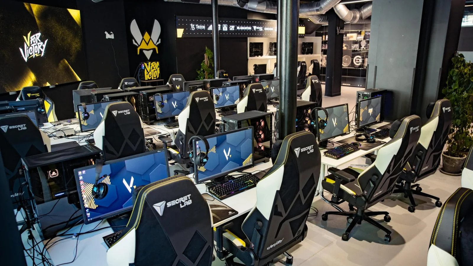 Team Vitality's V.Hive gaming area with rows of gaming PCs, monitors, headsets and Secretlab chairs