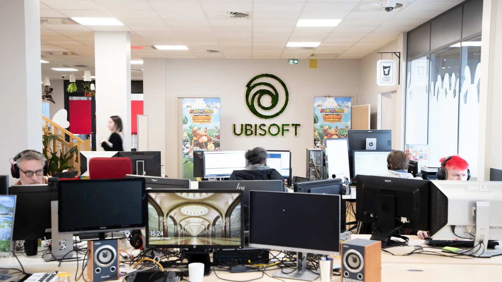 Ubisoft Paris studio interior with developers at work and a large Ubisoft logo on the wall